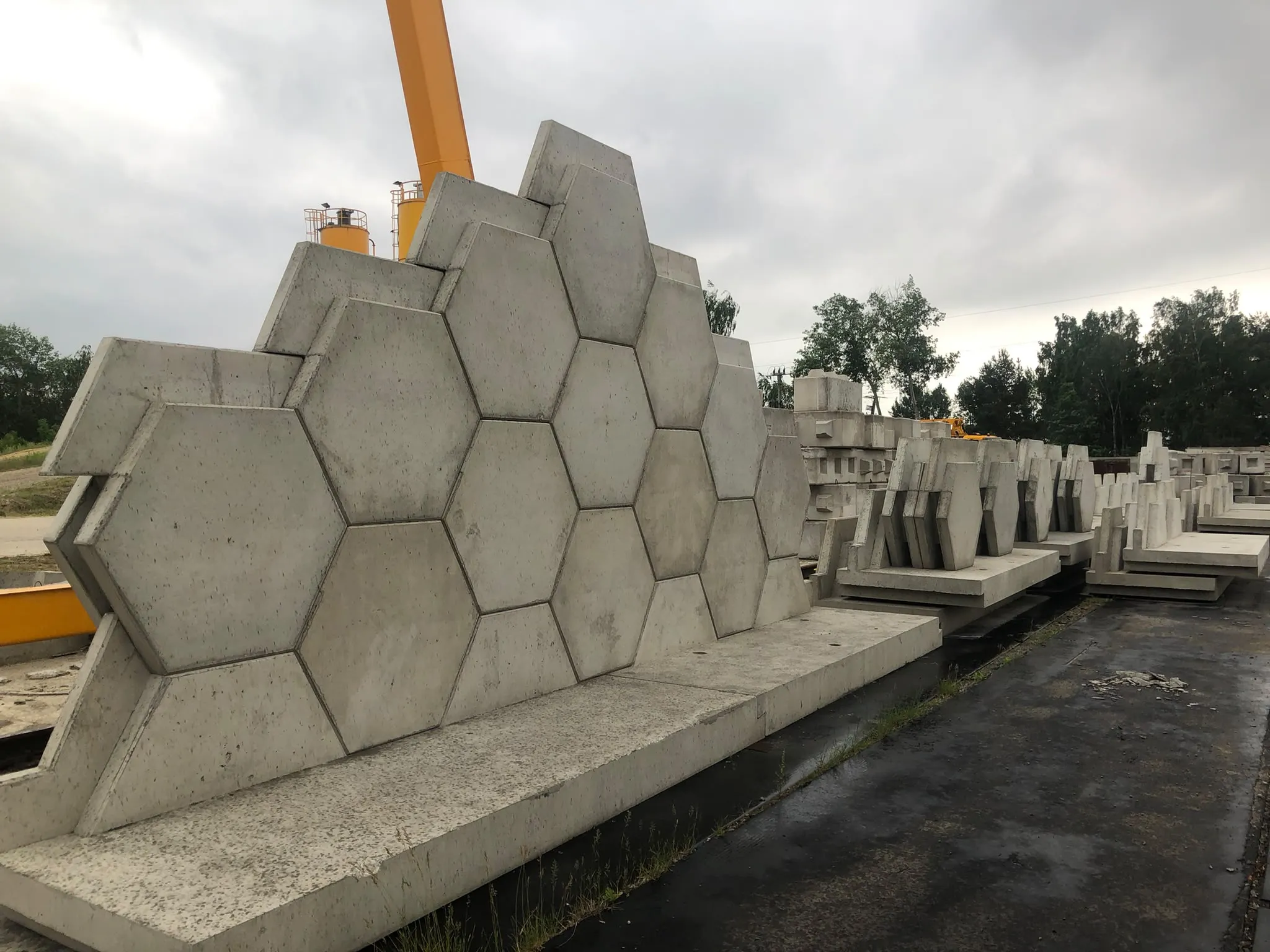 Rzeczywiste elementy MMEK SYSTEM ułożone w ścianę na betonowej podstawie na placu produkcyjnym